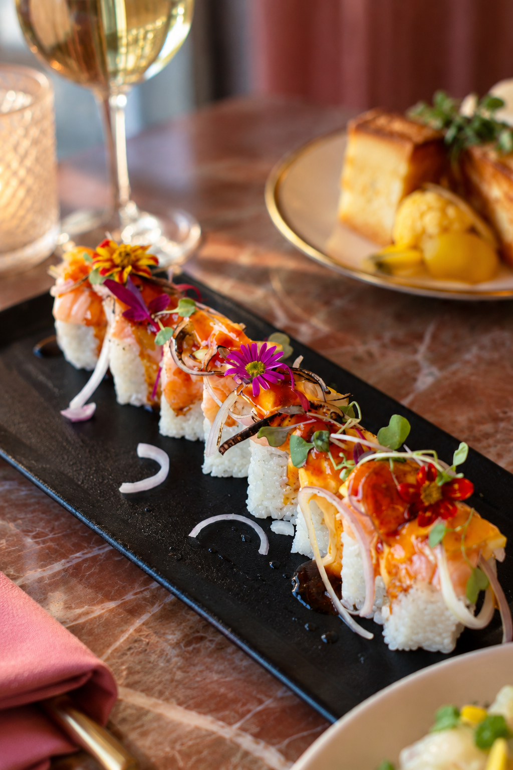 Sushi on slate garnished with edible flowers